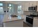 Modern kitchen with stainless steel appliances, granite countertops, a spacious island, and white cabinets at 71 Furley St, Homesite 116, Sanford, NC 27330