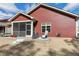 Red home exterior featuring a screened-in porch, patio space with chairs, and stairs down to a lawn at 80 Thornwhistle Pl, Garner, NC 27529