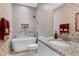 Bathroom features a freestanding soaking tub, decorative tile detail and stylish wall coverings at 80 Thornwhistle Pl, Garner, NC 27529