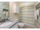 Bathroom with a vanity featuring granite countertops, toilet, cabinet, and shower with beautiful botanical wallpaper at 80 Thornwhistle Pl, Garner, NC 27529