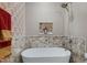 Close up of the freestanding soaking tub with decorative tile backsplash and elegant fixtures at 80 Thornwhistle Pl, Garner, NC 27529