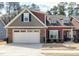 Charming home boasts a mix of stone and siding, complemented by a two-car garage and well-manicured landscaping at 80 Thornwhistle Pl, Garner, NC 27529