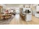 Open-concept kitchen with island seating, white cabinets, stainless steel appliances, and hardwood flooring at 80 Thornwhistle Pl, Garner, NC 27529