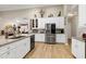 Modern kitchen with granite countertops, stainless steel appliances, white cabinetry, and hardwood floors at 80 Thornwhistle Pl, Garner, NC 27529