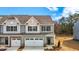 Charming townhome showcasing a stone facade and a two-car garage at 807 Pryor St # 45, Mebane, NC 27302
