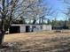 Outbuilding featuring a shed, doors and a blue barrel in a spacious yard at 9321 Stephenson Adams Ln, Willow Springs, NC 27592