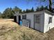 Outbuilding with white siding and doors in a spacious yard with pine trees at 9321 Stephenson Adams Ln, Willow Springs, NC 27592