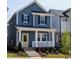 Charming two-story blue home featuring a welcoming front porch and bright yellow front door at 934 Allen Park Dr, Knightdale, NC 27604