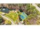 An aerial view of a park featuring tennis courts, a pond with a fountain, and a playground surrounded by trees at 112 Parkmeadow Dr, Cary, NC 27519