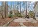 Landscaped backyard with stone retaining wall, a brick patio, and seating area, offering a private outdoor retreat at 112 Parkmeadow Dr, Cary, NC 27519