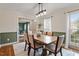 Dining room with hardwood floors, modern lighting, half green walls, and an open doorway to the living area at 112 Parkmeadow Dr, Cary, NC 27519