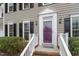 Close-up of the home's inviting purple front door, flanked by elegant black shutters and manicured bushes at 112 Parkmeadow Dr, Cary, NC 27519