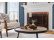 Living room features a fireplace with decorative mantle and round coffee table with decor at 112 Parkmeadow Dr, Cary, NC 27519
