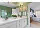 Modern main bathroom featuring double sinks, white cabinets, and a green painted wall at 112 Parkmeadow Dr, Cary, NC 27519