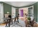 Office with green walls, natural light, hardwood floors, with a view into the dining and entry areas at 112 Parkmeadow Dr, Cary, NC 27519