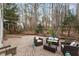 Paver patio with outdoor seating surrounded by a wooded backyard at 112 Parkmeadow Dr, Cary, NC 27519