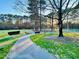A scenic walking path leads through a park, with tennis courts visible in the background, creating a serene atmosphere at 112 Parkmeadow Dr, Cary, NC 27519