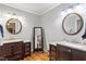 Dual sink bathroom with hardwood floors, round mirrors, and vanity at 118 Flora Mcdonald Ln, Cary, NC 27511
