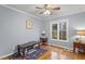 Cozy bedroom featuring hardwood floors, a bright window, and a comfortable seating area at 118 Flora Mcdonald Ln, Cary, NC 27511