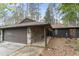 Charming single-story home featuring a stone-accented facade, brown garage door and covered porch at 118 Flora Mcdonald Ln, Cary, NC 27511
