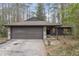 Charming single-story home featuring a stone-accented facade, brown garage door and wooded surroundings at 118 Flora Mcdonald Ln, Cary, NC 27511