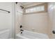 Bathtub with tile surround, natural light, and bronze fixtures at 1196 Smith Creek Way, Wake Forest, NC 27587