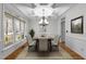 Bright dining room featuring decorative tray ceiling, large windows, chandelier and space for a table for six at 1196 Smith Creek Way, Wake Forest, NC 27587