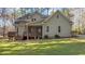 Rear exterior view featuring a deck, screened porch, and well-manicured landscaping, backing into wooded area at 1196 Smith Creek Way, Wake Forest, NC 27587