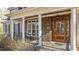 Inviting front entrance with stone accents, pillars and a wooden door with decorative glass at 1196 Smith Creek Way, Wake Forest, NC 27587