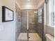 Modern bathroom featuring a shower with glass doors, gray tile, and ample lighting at 1205 Coral Cay Bnd, Wake Forest, NC 27587