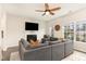 Inviting living room with large gray couch, fireplace, ceiling fan, and bright natural light at 121 Black Oak Ct, Clayton, NC 27520