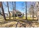 Spacious backyard with mature trees, a covered patio, and play equipment at 131 Tracker Ct, Garner, NC 27529