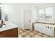 Bathroom features a soaking tub next to a window providing natural light, and tiled flooring at 131 Tracker Ct, Garner, NC 27529