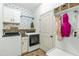 Well-organized laundry room features washer, dryer, storage cabinets, shelving, and stylish wallpaper at 131 Tracker Ct, Garner, NC 27529