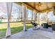 Covered patio with sheer curtains offering a view of the grassy backyard at 131 Tracker Ct, Garner, NC 27529