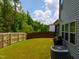 Private backyard featuring a wood fence, lush green lawn, and mature trees at 1401 Wrenn Rd, Durham, NC 27703