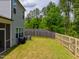 Spacious backyard featuring a wood fence, lush green lawn, and mature trees at 1401 Wrenn Rd, Durham, NC 27703