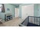 Bedroom featuring blue walls and carpeting with a changing table and crib at 1401 Wrenn Rd, Durham, NC 27703