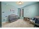 Bedroom featuring blue walls and carpeting with a crib and rocking chair at 1401 Wrenn Rd, Durham, NC 27703
