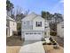 Charming two-story home boasts a yellow front door, attached garage, and landscaped front yard at 1401 Wrenn Rd, Durham, NC 27703