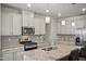 An open kitchen with stainless steel appliances, tile backsplash and a granite-topped island that offers additional seating at 1401 Wrenn Rd, Durham, NC 27703