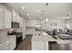 Open concept kitchen and living area features an island with seating, stainless appliances, and modern cabinetry at 1401 Wrenn Rd, Durham, NC 27703