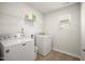 Bright laundry room features white appliances and shelving for organized storage at 1401 Wrenn Rd, Durham, NC 27703