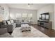 A gray sectional sofa and soft rug complements the living room with natural light from the windows at 1401 Wrenn Rd, Durham, NC 27703