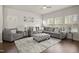 Comfortable living room with gray sectional sofa, patterned ottoman, and soft rug over wood floors at 1401 Wrenn Rd, Durham, NC 27703