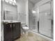 This bathroom includes a walk-in shower with glass door, neutral tile, and dark vanity at 1419 Glenwater Dr, Cary, NC 27519
