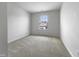 Simple bedroom features neutral carpet, white walls, and a window for natural light at 1419 Glenwater Dr, Cary, NC 27519