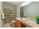Bathroom with wood vanity, framed mirror, colorful shower curtain and neutral tile flooring at 174 Coalyard Dr, Garner, NC 27529