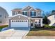 Charming two-story home with a well-manicured lawn and a two-car garage at 174 Coalyard Dr, Garner, NC 27529
