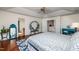 Bright main bedroom featuring tray ceiling, ceiling fan, hardwood floors and doorway to bathroom at 174 Coalyard Dr, Garner, NC 27529